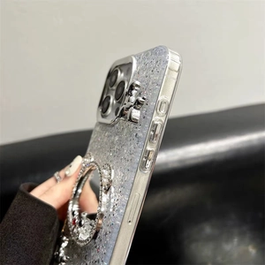 Gedetailleerd zijaanzicht van zilveren glitterhoesje met 3D-figuur en strassteentjes ring