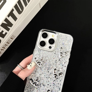 Close-up of glittery silver iPhone case featuring 3D metallic hearts and luxury finish