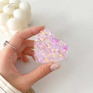 Close-up of glittery heart phone grip holder with purple and yellow resin flakes