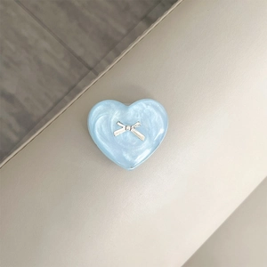 Macro detail of a 3D heart phone socket with a silver bow on pearlescent blue finish