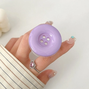 Close-up of a purple button-shaped expanding phone grip holder with glossy finish