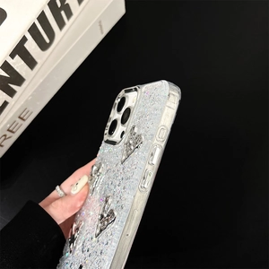 Detail of iPhone glitter case with silver heart charms and side button texture