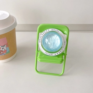 Detail of light green foldable chair phone stand with blue glittery gift disc