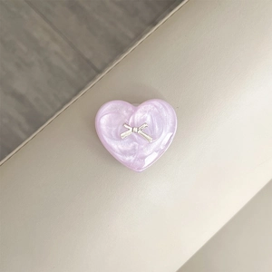 Detail of purple heart phone grip with pearl texture and silver ribbon bow decoration