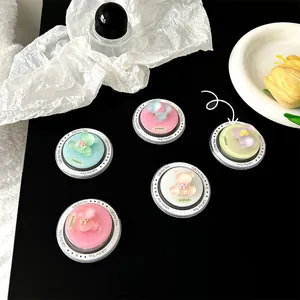 Detail of colorful 3D resin bear phone grips on black surface with aesthetic decor