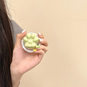 Detail shot of a cute green cat paw shaped retractable phone grip stand held in hand