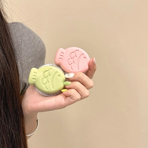 Detailed view of fish-shaped magnetic phone holders in pink and green with Gift For You label