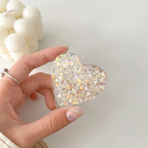 Close-up of heart-shaped Griptok with colorful sequins and acrylic finish on a phone
