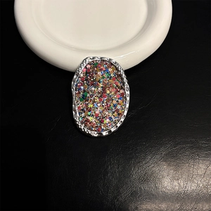 Detail of silver textured phone grip featuring colorful sequins and glitter design