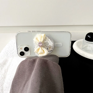 Detail of lace bow phone stand with pink rhinestones and silver charm on iPhone case