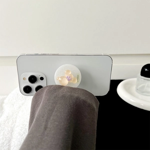 Magnetic glitter bear phone socket stand with purple bow on a white smartphone