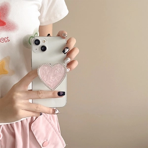 Detailed view of heart-shaped magnetic phone grip with pink marble texture and rhinestones