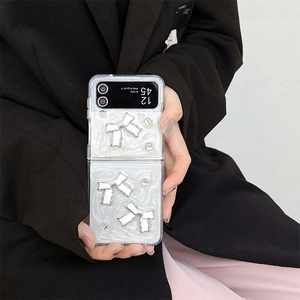 Vue détaillée de la coque ondulée blanc perle avec nœuds argentés et strass pour Z Flip