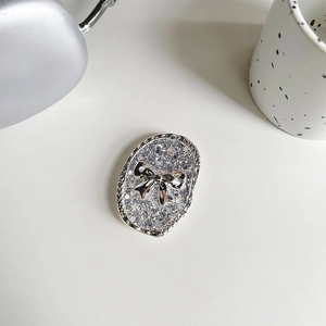 Close-up of glittery oval phone grip featuring a silver bow and laser sequins