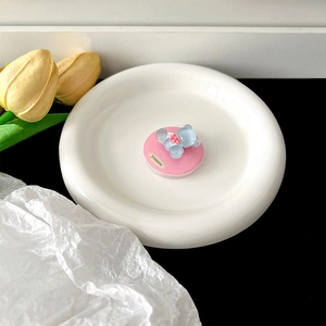 Detail of glittery bear phone grip with magnetic base on a white ceramic plate