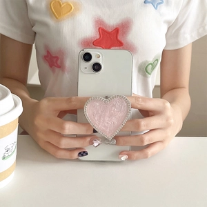Detail of pink marble heart phone grip with silver rhinestones on a white phone case
