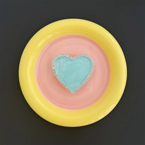 Macro shot of a heart-shaped magnetic phone grip with blue marble pattern and rhinestones