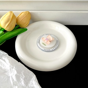 Detail of pink glitter bear magnetic phone grip on a white plate with floral decoration