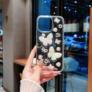 Détail de la coque iPhone avec papillons en perles et cœurs sur fond noir pailleté