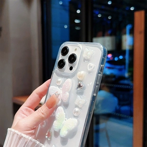 Détail de coque iPhone transparente avec papillons 3D en résine, perles et strass