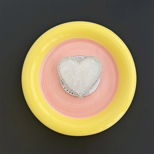 Detail of heart-shaped magnetic phone grip with white marble texture and rhinestone rim