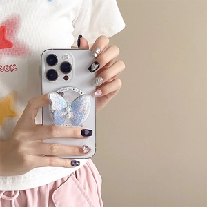 Close-up of a blue embroidered butterfly phone socket with pearl accents on a white phone