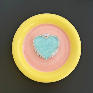Close-up of heart-shaped magnetic phone grip with blue marble pattern and rhinestones