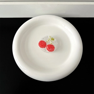 Macro shot of handcrafted beaded cherry phone grip with glitter on a white ceramic plate