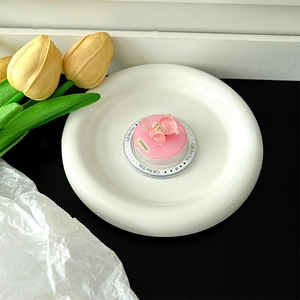 Detail of pink resin bear phone grip with glitter finish inside a white ceramic dish