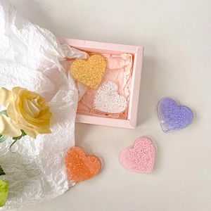Glitzernde herzförmige Handyhalterungen in fünf Bonbonfarben mit einer Geschenkbox