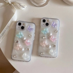 Détail de coque iPhone transparente avec papillons 3D, perles et strass brillants