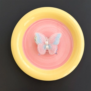 Detailed view of butterfly embroidery phone grip with gradient fabric and pearl accents