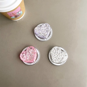 Three sequined heart-shaped phone grips in pink, purple, and silver on gift cards