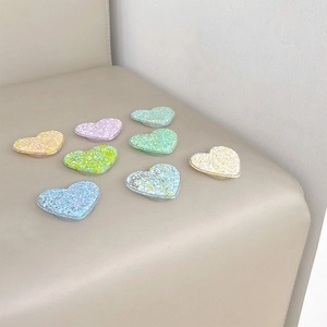 Colorful glitter heart-shaped phone grip stand in various macaron colors on leather