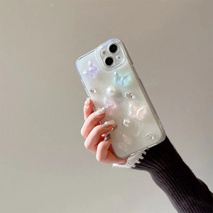 Détail d'une coque iPhone transparente avec papillons 3D dégradés, perles et strass brillants