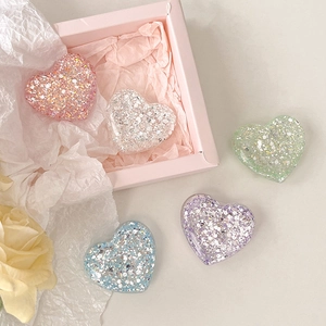 Detail of glitter heart phone grips in macaron colors with pink gift packaging