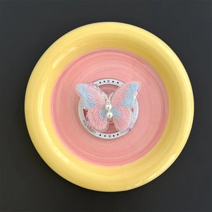 Detail of butterfly phone grip with pink gradient embroidery and white pearl accents