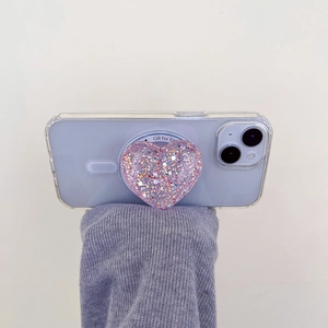 Macro detail of heart-shaped glitter phone socket on purple smartphone back