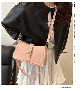 Detail view of pink pleated shoulder bag with gold H-buckle and textured finish