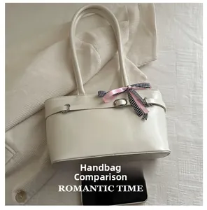 Detailansicht der cremefarbenen Lackleder-Umhängetasche mit Schleife und Handy-Größenvergleich