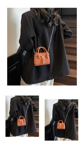 Mini orange-brown crossbody bag with silver chain strap and leather handle details