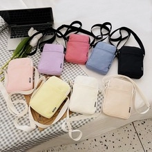 Flat lay of colorful mini nylon shoulder bags in eight candy colors with zipper pocket