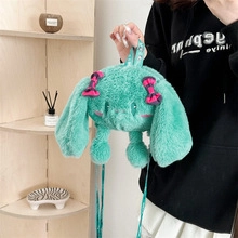 Detail of mint green plush handbag with pink checkered bows and embroidered face