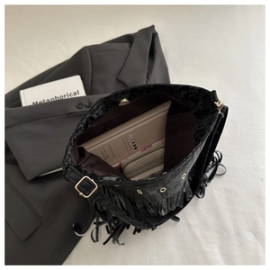 Dettaglio della borsa a secchiello nera con nappe e interno capiente per libri e accessori