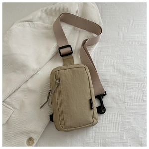 Detail der khakifarbenen Nylon-Brusttasche mit verstellbarem Gurt auf weißem Grund