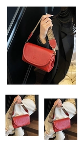 Detail of red square crossbody bag with ethnic wide strap and embossed fashion text