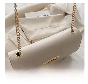 Détail du sac bandoulière blanc crème avec chaîne dorée et œillets métalliques