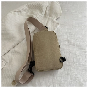 Close-up of khaki nylon chest bag with adjustable strap and textured fabric detail