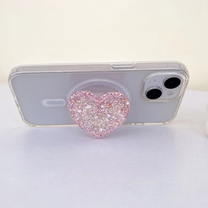 Detail of pink glitter heart phone socket grip with sparkling sequins on a transparent case