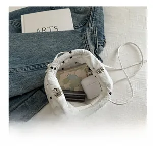 Top view of white floral bucket bag showing interior storage capacity for phone and earbuds